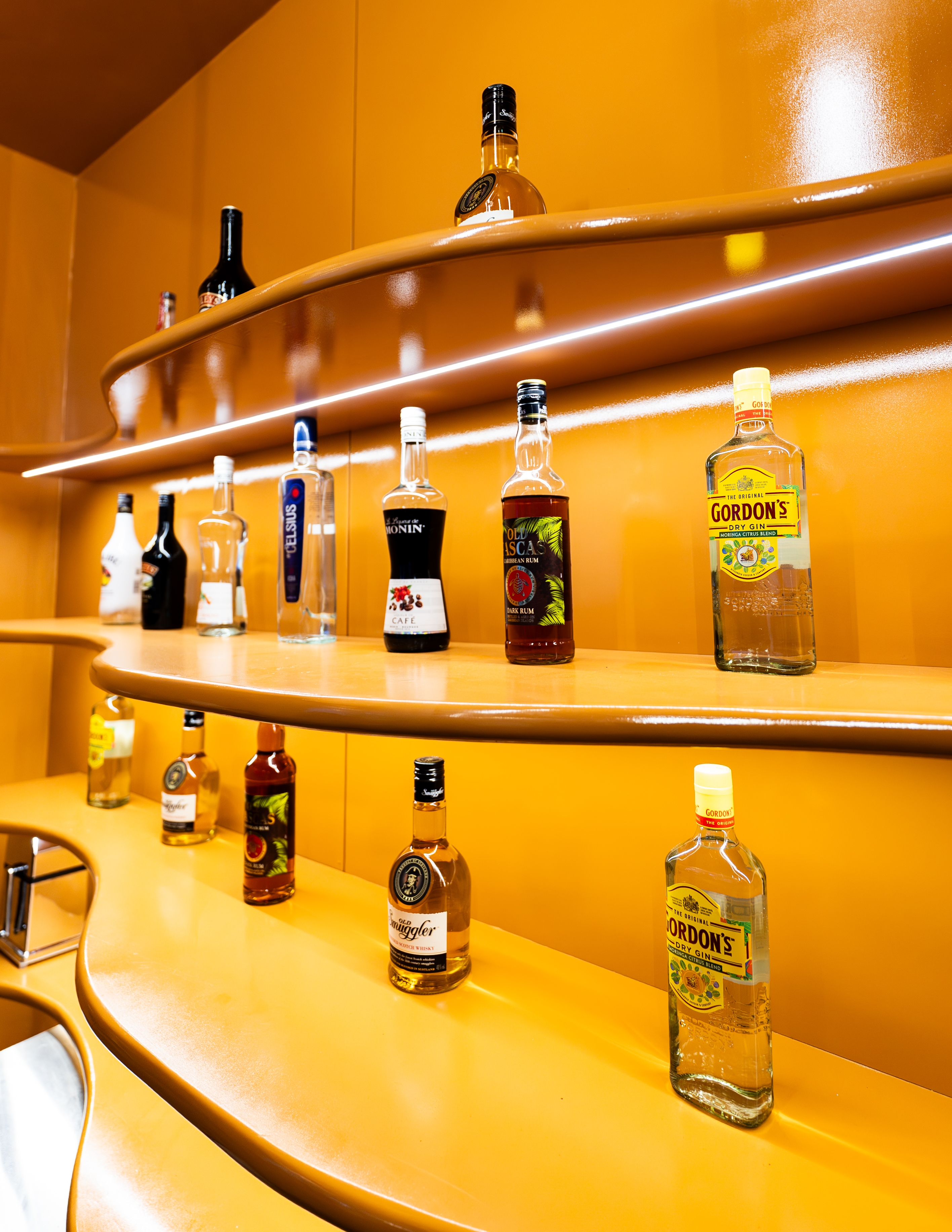 Backlit bar shelf stocked with spirits