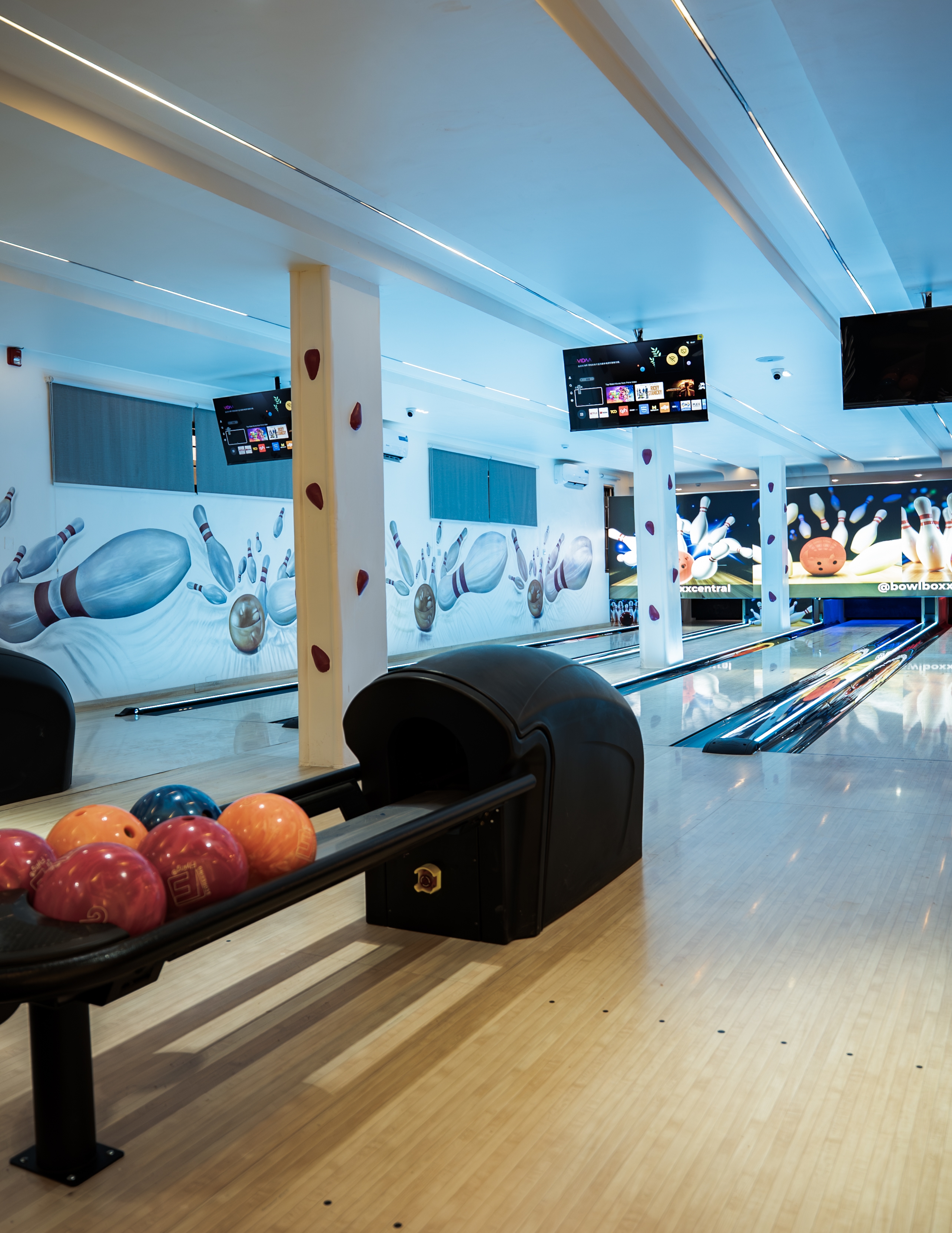 Bowling lanes lit up under neon light